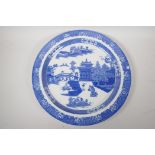 A Staffordshire blue and white charger decorated with the Long Bridge variation of the Willow