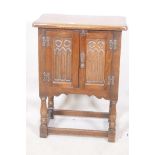 An oak two door cabinet with Gothic style carving, 20" x 13" x 27"