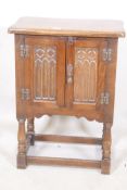 An oak two door cabinet with Gothic style carving, 20" x 13" x 27"