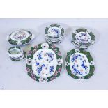 A Masons ironstone part dinner service decorated with Imari style flowers within a green border,
