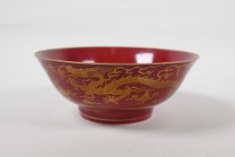 A Chinese red ground porcelain bowl with gilt lustre dragon decoration, six character mark to