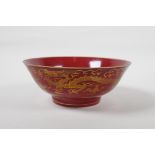 A Chinese red ground porcelain bowl with gilt lustre dragon decoration, six character mark to