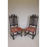 A pair of C19th oak Carolean style hall chairs with barleytwist columns and fruiting vine carved