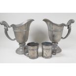 A pair of continental pewter ewers on pedestal bases, 9" high, and two antique half pint measures