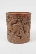 A Chinese carved bamboo brush pot decorated with figures, and elephant and a dragon, in a wooded