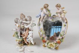A German porcelain figure of cherubs embracing a young woman, together with a heart shaped