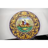 An Italian fayence pottery charger, painted with a horseman and his dog, within an elaborate '