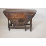 An C18th oak drop leaf table raised on turned supports with shaped block ends, 41" x 15" x 26"