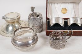 A hallmarked silver capstan inkwell, A/F, together with a cased pair of hallmarked silver napkin
