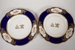 A pair of C19th Armorial porcelain plates decorated with two crest, a deer with rose and flag, and a