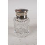 A cut glass scent bottle with a sterling silver and tortoiseshell cup, the lid with inset silver