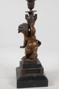 A C19th bronze candlestick cast as a cherub, raised on stepped marble base, 13" high