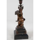 A C19th bronze candlestick cast as a cherub, raised on stepped marble base, 13" high