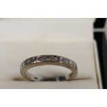 A hallmarked 18ct white gold half eternity ring, set with eleven princess cut diamonds, .5ct