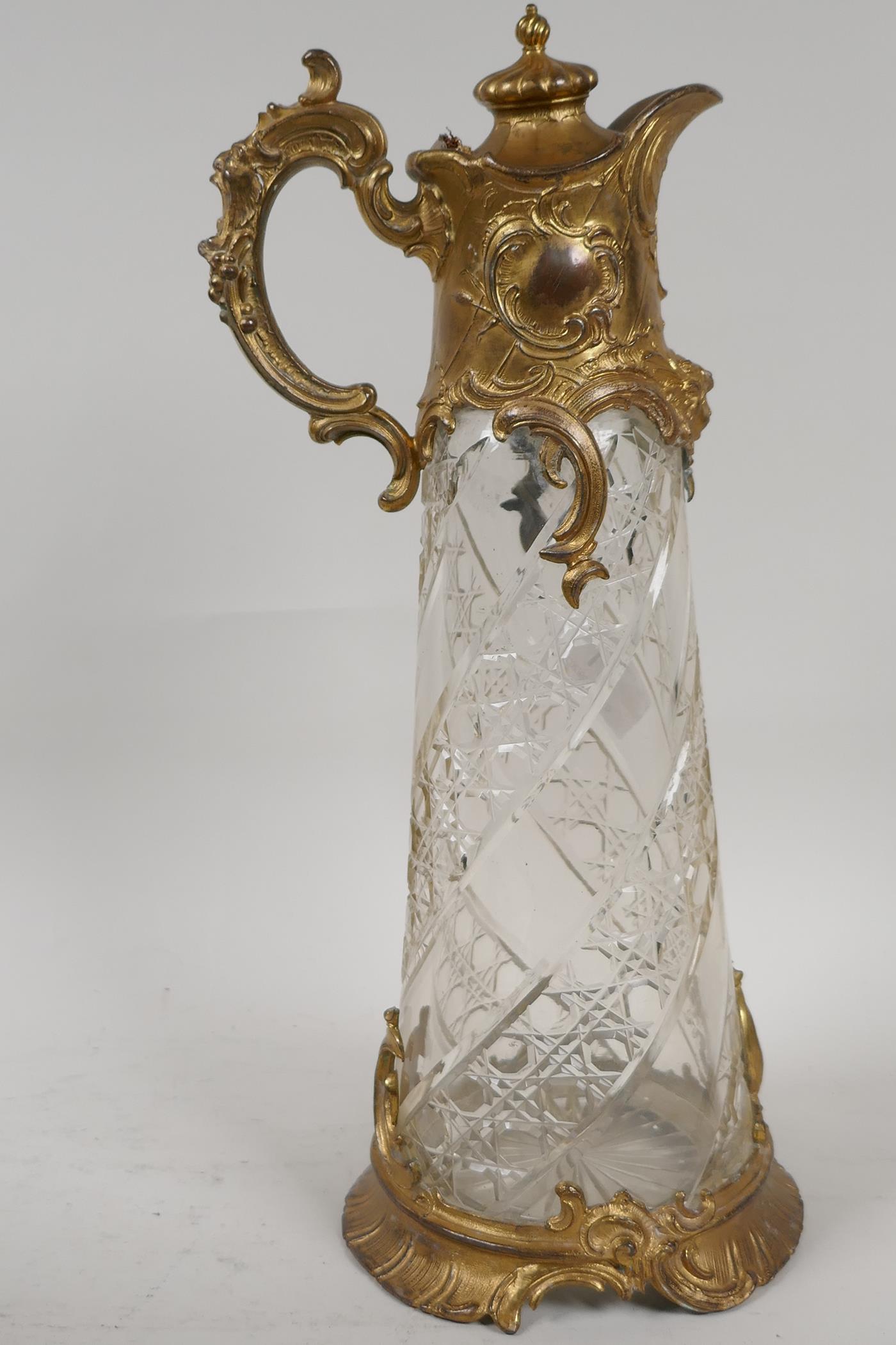 A C19th gilt metal and cut glass claret jug, 12" high