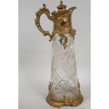 A C19th gilt metal and cut glass claret jug, 12" high