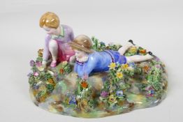 A mid C20th Crown Staffordshire figure, children in a bed of flowers, modelled by T. Bayley, 12"