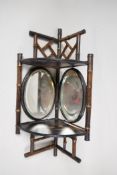 A C19th bamboo and lacquer corner wall shelf with two bevelled glass mirrrors and two shelves,