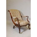 A Victorian rosewood show frame open arm easy chair, with scrolled back and shaped arms, raised on