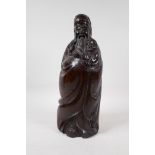 A Chinese carved hardwood figure of a sage carrying a child, 15" high