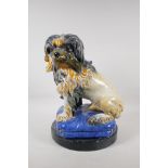 A Majolica pottery dog on a blue pillow, 16" high