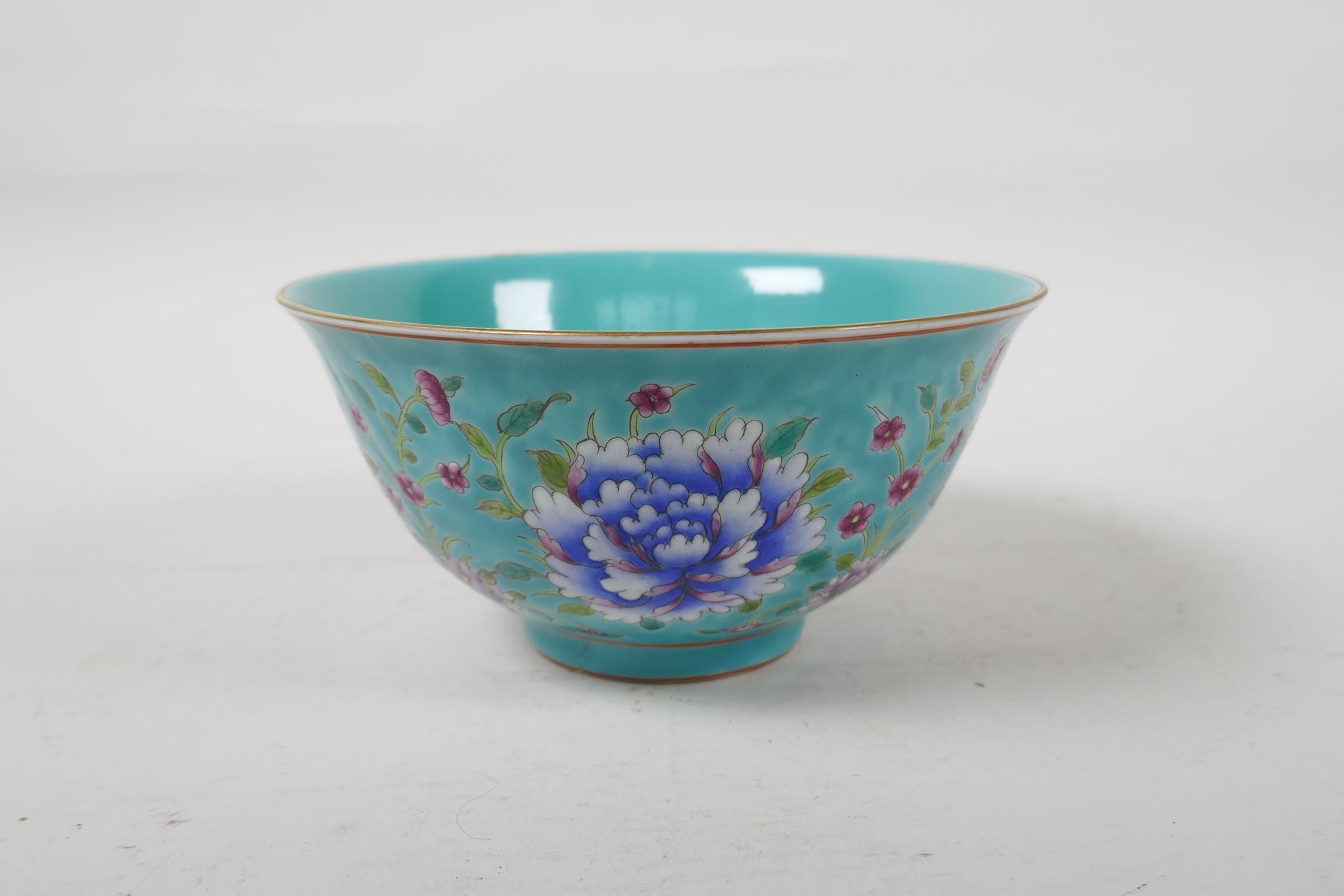 A polychrome porcelain rice bowl with enamelled floral decoration on a turquoise ground, Chinese