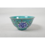 A polychrome porcelain rice bowl with enamelled floral decoration on a turquoise ground, Chinese
