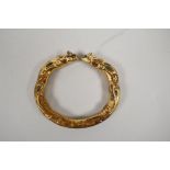 A Chinese gilt metal bangle with rat head decoration and inset with turquoise and coral, 3" diameter