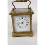 A brass cased carriage clock with bevelled glass panels, white enamel dial and Roman numerals, 4"