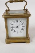 A brass cased carriage clock with bevelled glass panels, white enamel dial and Roman numerals, 4"