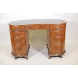 A late C19th/early C20th walnut kidney shaped pedestal desk with leather tooled top and nine drawers