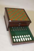 A mahogany three drawer chess and backgammon board, with a complete set of resin chess pieces, A/