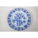 An early C19th Delft blue and white pottery charger painted with flowers, 14" diameter