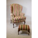 A high wing armchair on cabriole legs, upholstered in Regency Stripe fabric, with matching footstool