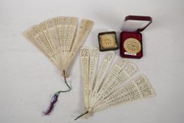 Two C19th carved bone fans, 7½" long, and two antique pierced ivory roundels