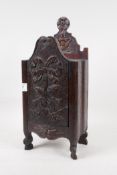 A C19th French carved wood candle box in the form of an armoire, with sliding door, 14" high