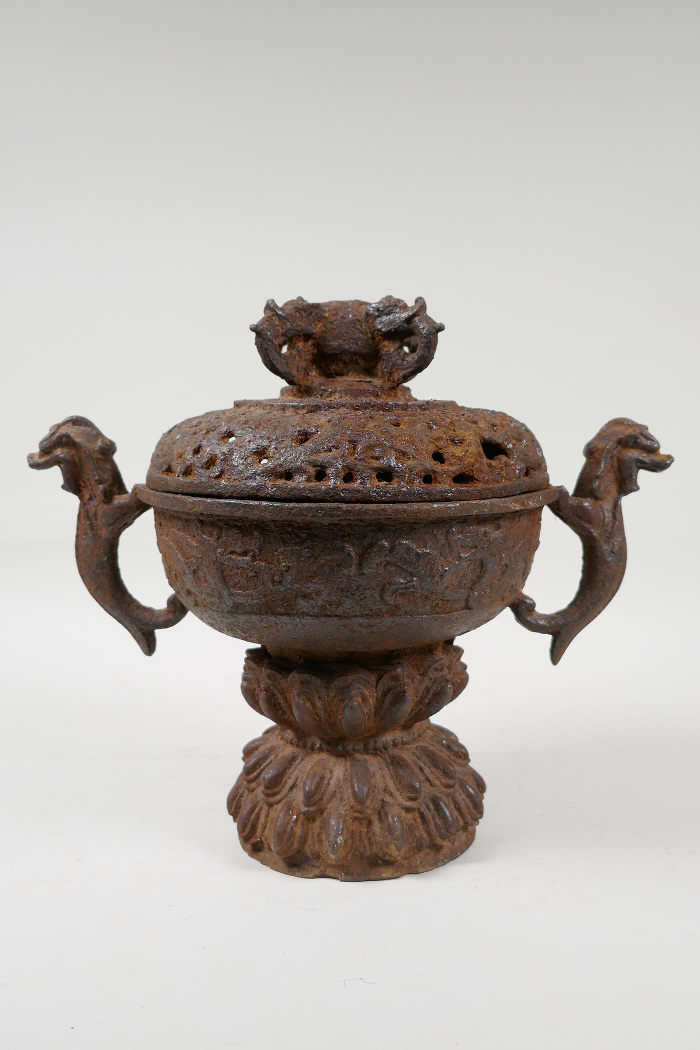 A cast iron censer with two dragon shaped handles, and a pierced cover, Chinese, 9" high