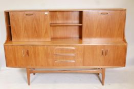 A 1960s/70s G Plan 'Fresco' teak highboard, with sliding door and fall front cocktail cabinet to the
