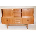 A 1960s/70s G Plan 'Fresco' teak highboard, with sliding door and fall front cocktail cabinet to the