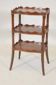 A Victorian mahogany three tier whatnot on sabre legs, 11" x 14", 26" high