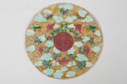 A Chinese Sancai glazed porcelain panel with raised peach, bat and auspicious symbol decoration, 8½"