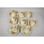 A set of eight Royal Worcester porcelain cups and saucers painted with autumnal flowers on a blush