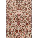 A French sarouk style ivory ground wool carpet, decorated with a floral design with red borders, 73"