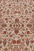 A French sarouk style ivory ground wool carpet, decorated with a floral design with red borders, 73"