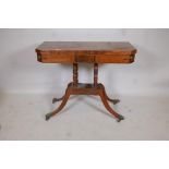 A Regency inlaid figured mahogany card table with canted corners raised on ring turned columns,