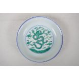 A Chinese blue and white porcelain dish with green enamel dragon decoration, six character mark to