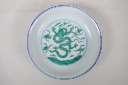 A Chinese blue and white porcelain dish with green enamel dragon decoration, six character mark to