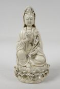 A blanc de chine porcelain Quan Yin seated on a lotus flower, impressed marks verso, 10½" high