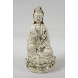 A blanc de chine porcelain Quan Yin seated on a lotus flower, impressed marks verso, 10½" high