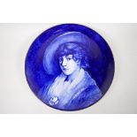 A blue and white pottery charger with painted portrait of a young girl, detailed verso D. Simpson